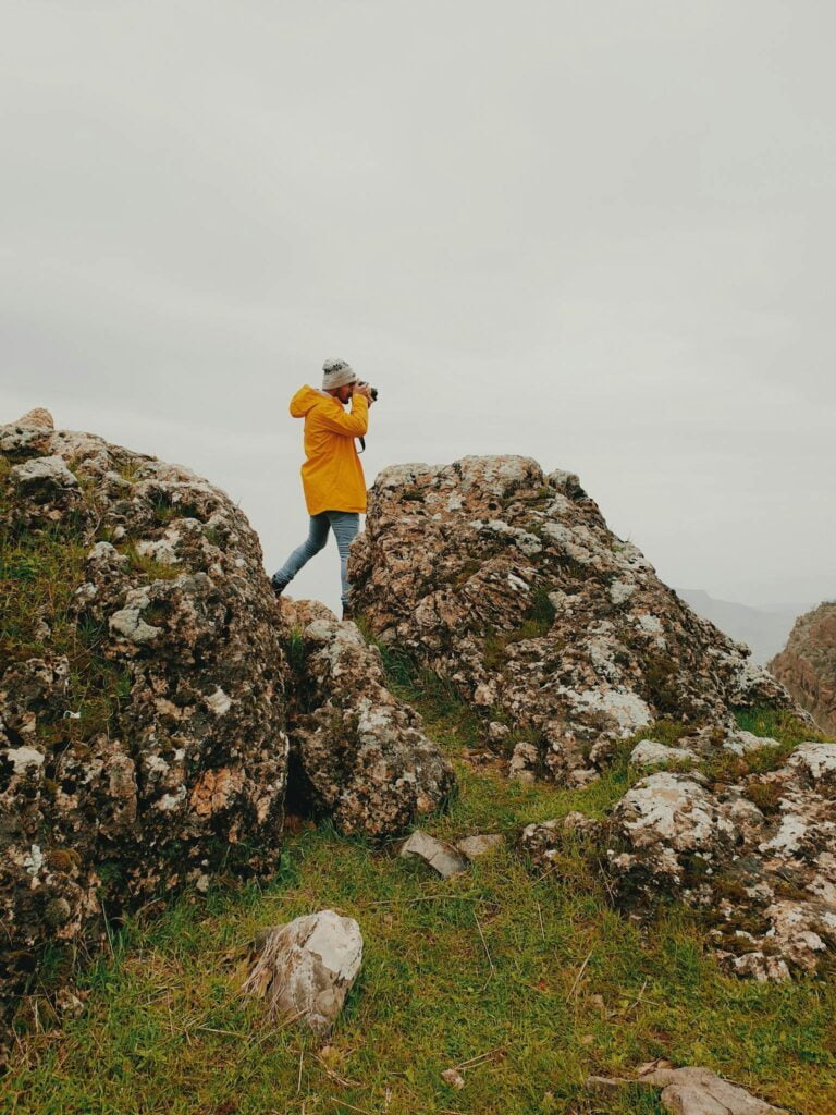 Anonymous female photographer shooting nature during hiking trip